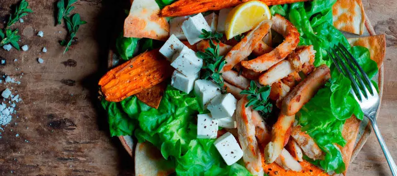 Ensalada de pollo con hojas verdes y tortillas